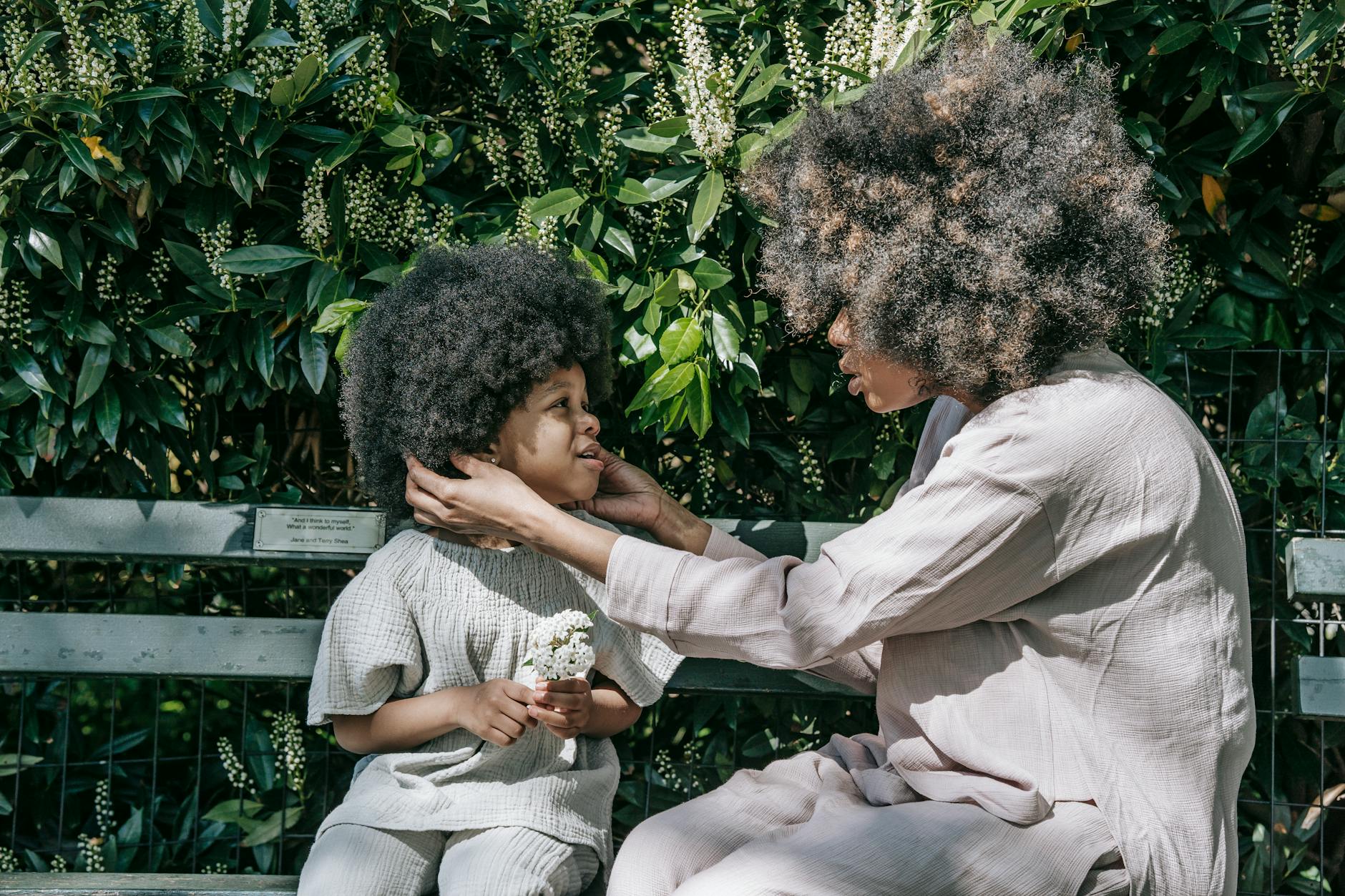 Mama przytula małe dziecko podczas spaceru w zielonym parku