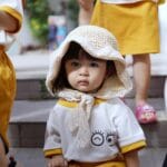 Powolne oswajanie z grupą: mikroadaptacje dla wyjątkowo nieśmiałych i lękowych dzieci Nieśmiała dziewczynka w mundurku i czapce przed wyjściem do przedszkola