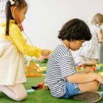 Dzieci bawiące się wspólnie w kolorowej sali przedszkola