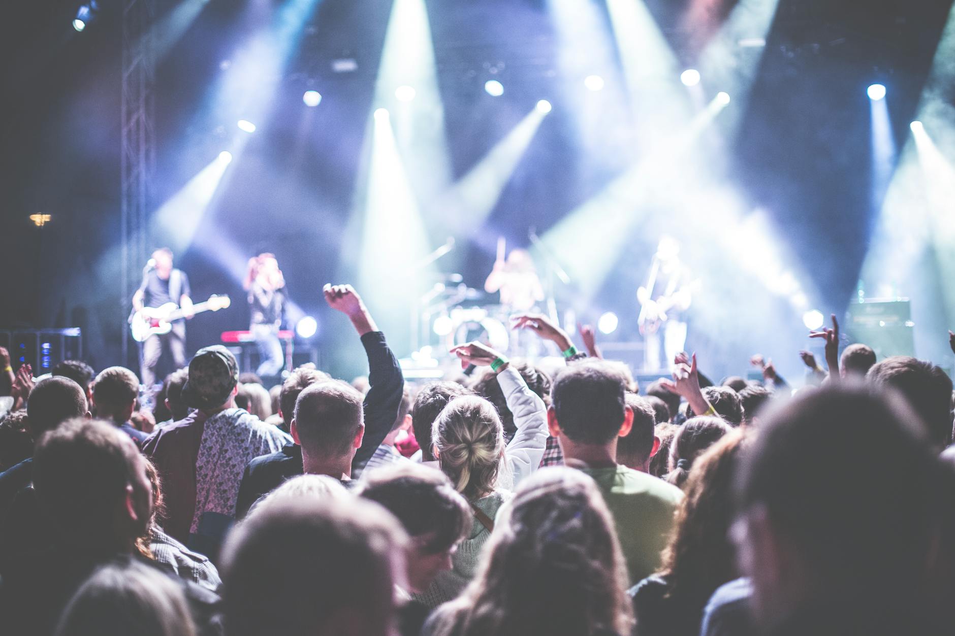 Energetyczny koncert rockowy z publicznością pod jasnymi światłami sceny