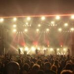 Tłum wśród świateł na nocnym rockowym koncercie na dużej scenie