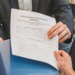 Dłonie przekazujące w biurze wniosek o pożyczkę hipoteczną