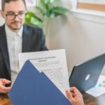 Doradca finansowy omawia z klientem wniosek o pożyczkę przy biurku