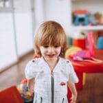 Uśmiechnięte przedszkolne dziecko w kolorowej sali zabaw