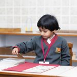 Dziecko rozwijające sprawność manualną podczas nauki metodą Montessori